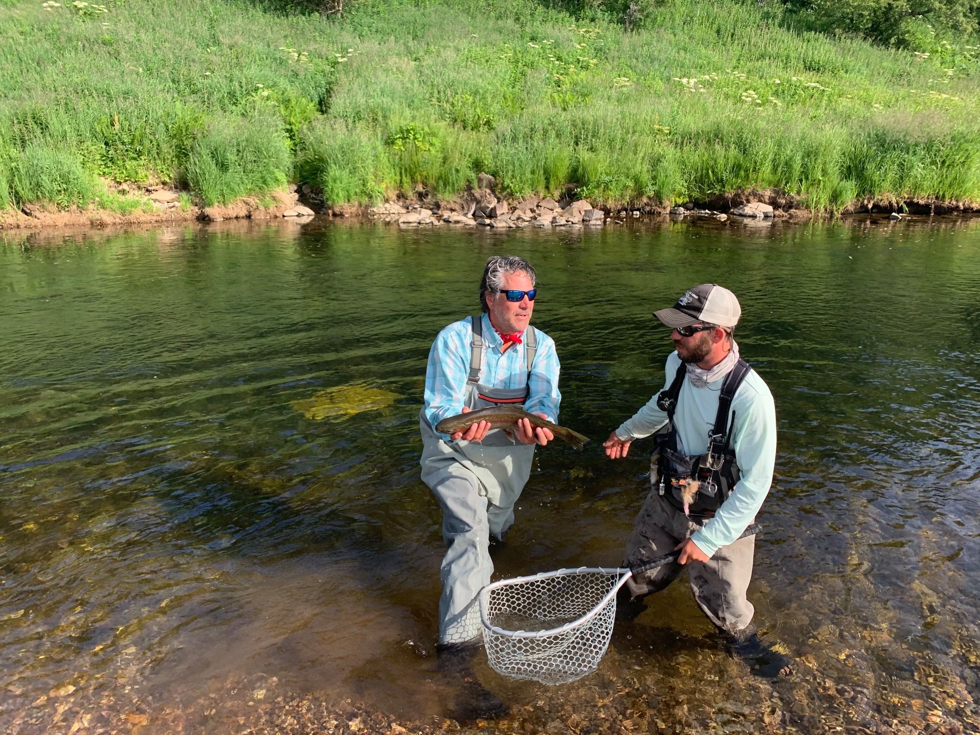 Rain gear angler huge rainbow trout