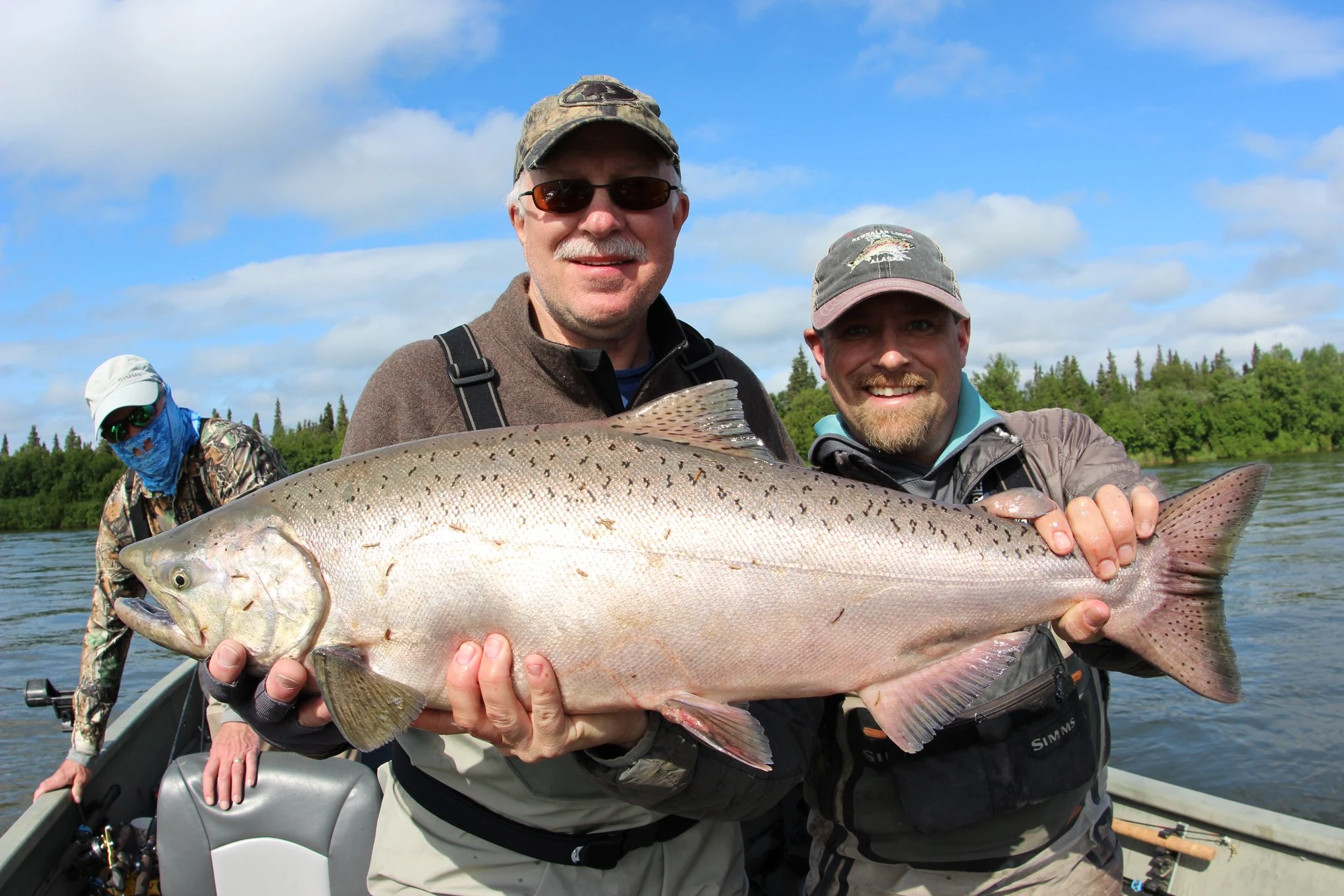 Two anglers holding an enormous trophy king salmon catch