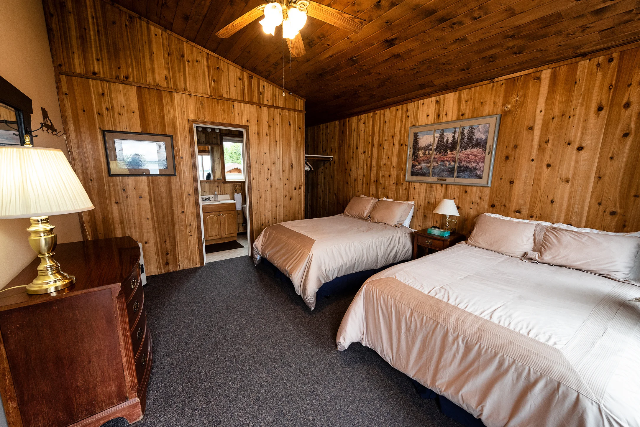 Private guest cabin bedroom suite with double beds and cedar wood panelling