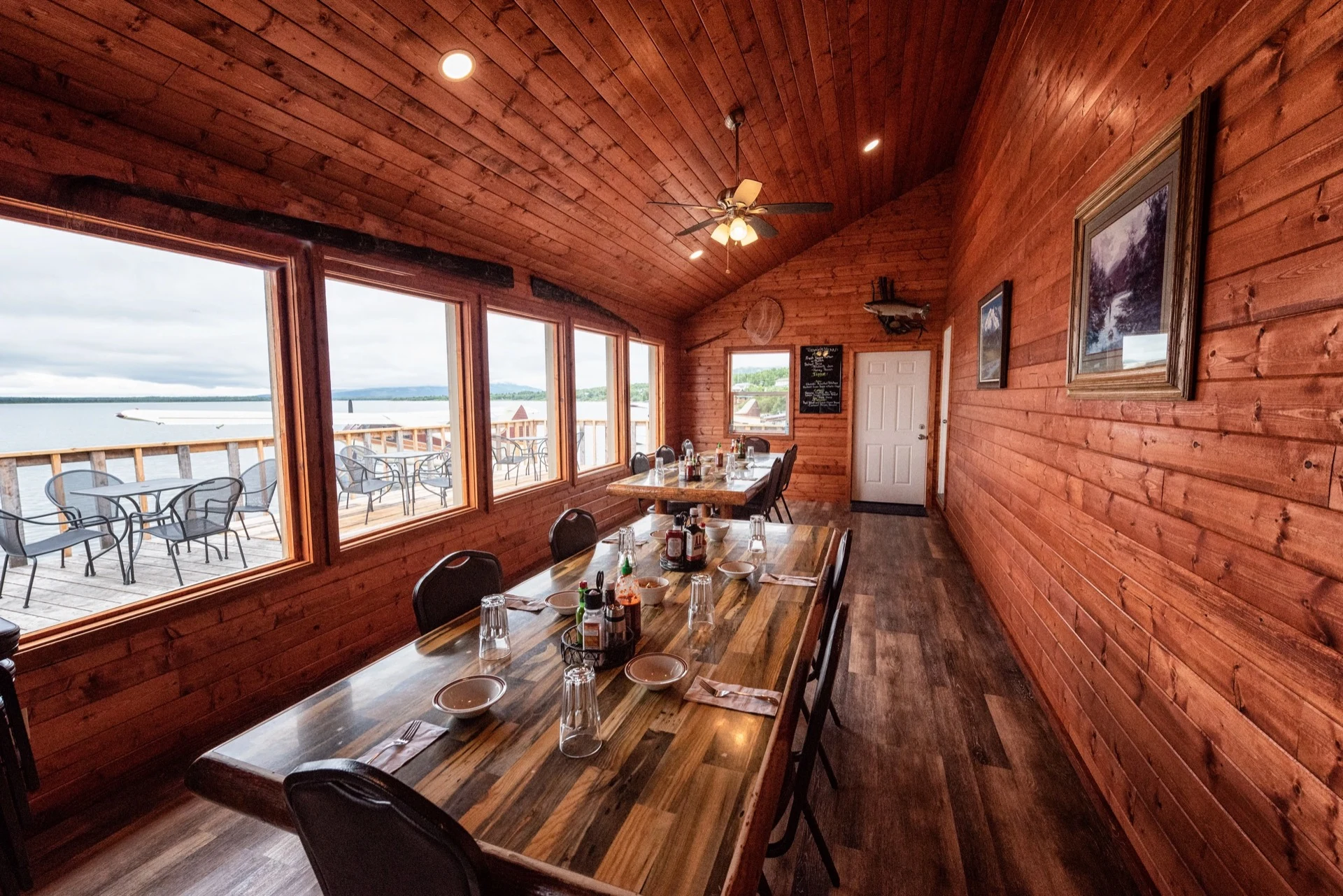 Newhalen Lodge dining room interior with panoramic lakefront windows and dock view — premium lodge experience